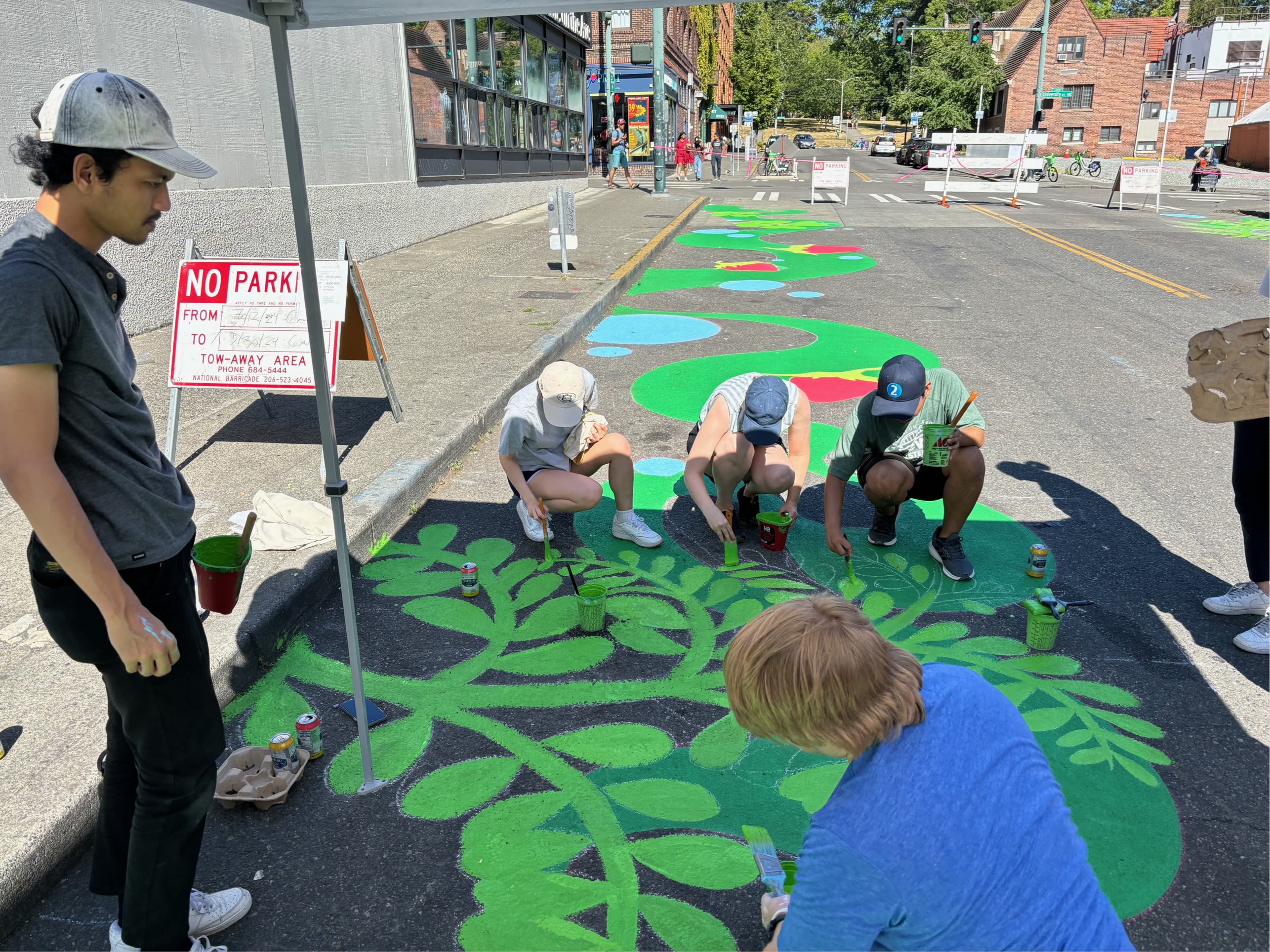 Volunteers painting the street mural